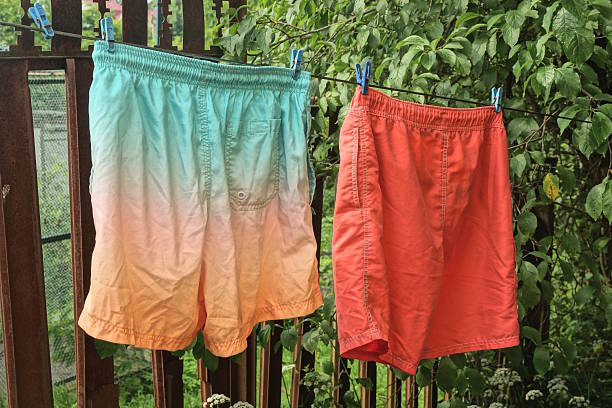 istock two colored and red beach shorts hanging on a wire 2222231759