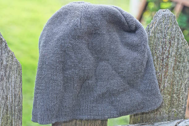 one gray woolen hat hangs on the wall on the autumn street