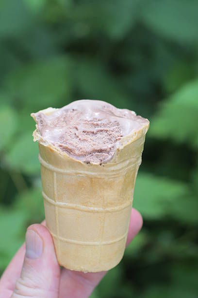 istock hand holding one brown ice cream in waffle cone 2222231984