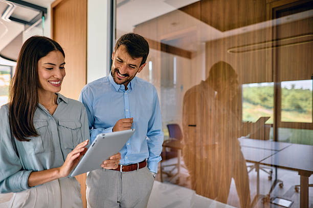 istock Smiling business partners reviewing project on digital tablet in modern office 2222232221