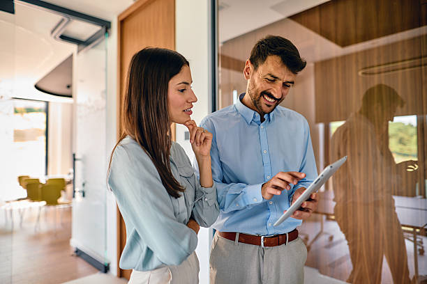 istock Business partners using tablet and discussing about work in modern office 2222232225