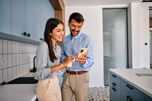 istock Smiling business people looking at smartphone and drinking coffee in the office kitchen 2222232264