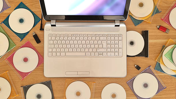 istock Aerial view of cd-rom media aound a white laptop 2222237538