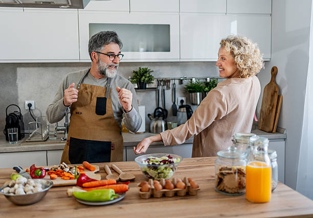 istock Happy mature couple dancing and having fun while cooking together in modern kitchen 2222244151