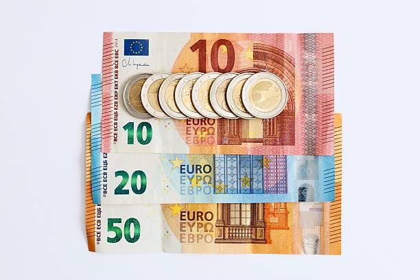 istock Euro coins on banknotes top view white background 2222244435