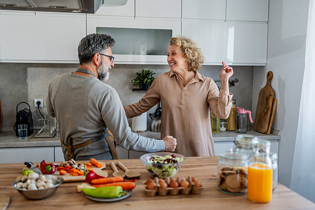 istock Happy mature couple dancing and having fun while cooking together in modern kitchen 2222244620