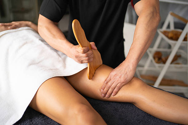 istock Masseur massaging woman's leg with wooden tool in spa 2222244900