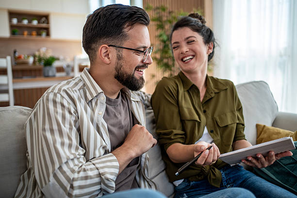 istock Young couple laughing and planning their future on sofa at home 2222245891