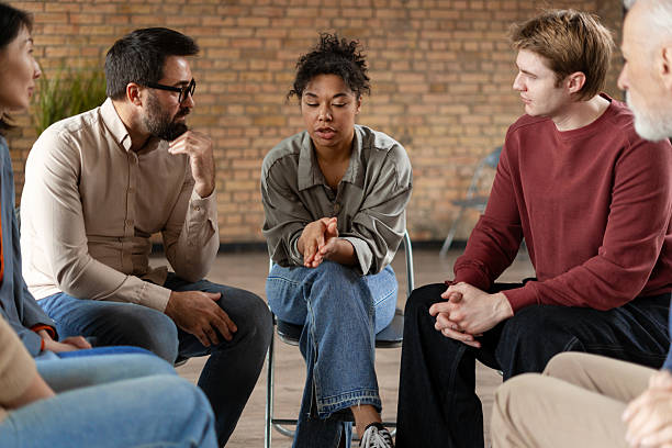 istock Diverse people sitting in circle supporting each other during group therapy session 2222246041