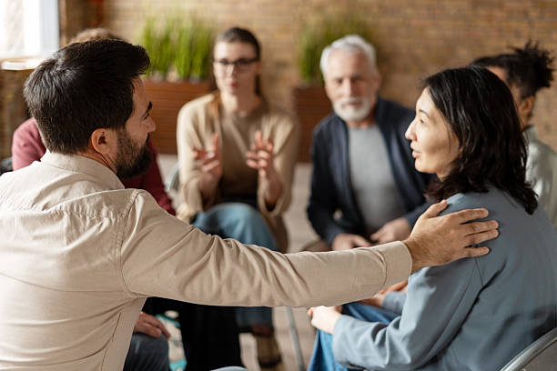 istock Psychotherapist comforting a woman during group therapy session 2222246122