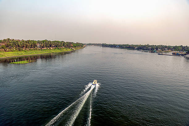 istock Boat cruising on a calm river surrounded by lush greenery during a tranquil sunset 2222247578