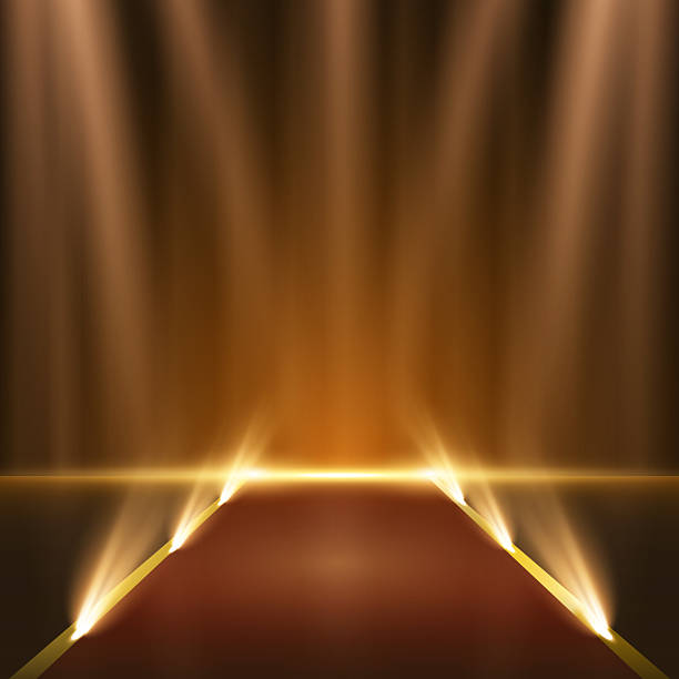 istock Golden stage with glowing spotlights and red carpet on dark background. Elegant podium illuminated by sparkling rays and festive particles, perfect for awards, ceremonies, or product showcase. 2222248102