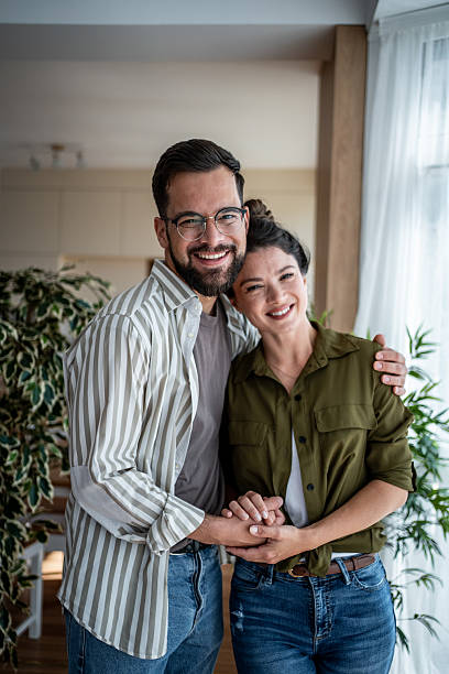 istock Happy young couple embracing and smiling at home 2222248954