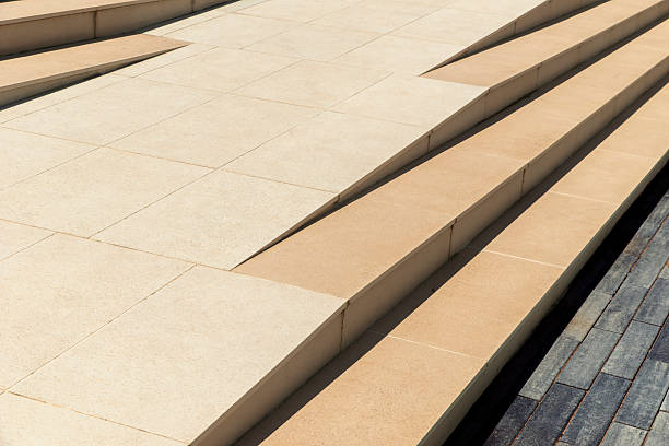 Monochrome detail of a wheelchair ramp through the steps of a staircase