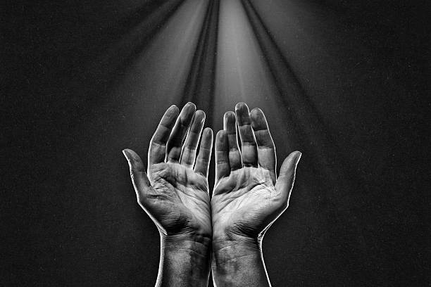 istock Hand Praying Reaching Light in Black and White 2222250581