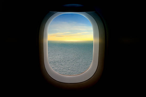 View from a plane window over the ocean landscape with a sunrise scene. Summer background