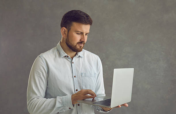 istock Serious young businessman developing online business using his modern laptop computer 2222259480