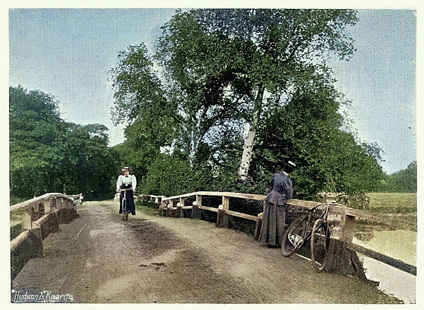 istock Two women cyclists on the bridge over the Mole, Byfleet, Surrey, Victorian, 1890s, Vintage colourised photograph 2222263527
