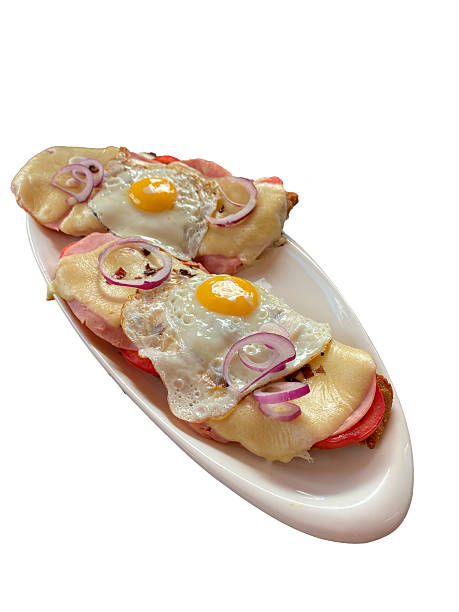 istock Breaded meat topped with fried eggs, melted cheese, tomato slices and red onion rings. 2222263799