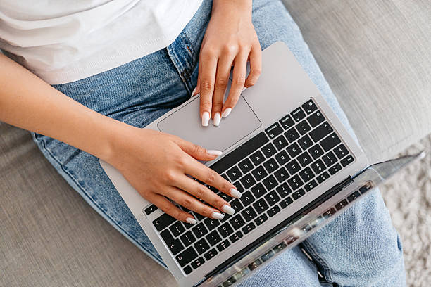 istock Young Woman Working On A Laptop While Sitting On The Sofa At Home 2222264210