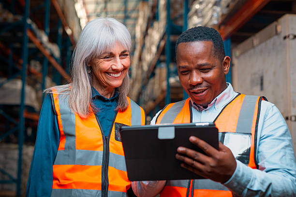 istock Warehouse Workers Collaboratively Reviewing Logistics on a Digital Tablet in a Busy Storage Facility 2222265230