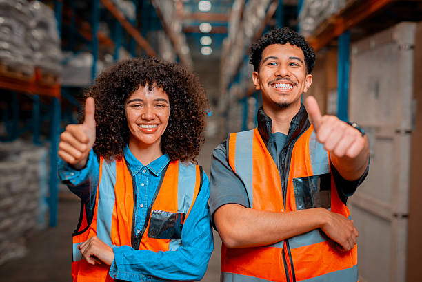 istock Warehouse Workers Smiling and Giving Thumbs Up in High Visibility Vests 2222265245