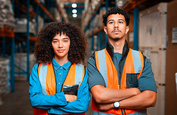 Warehouse Workers in High Visibility Vests Posing Confidently in Storage Facility