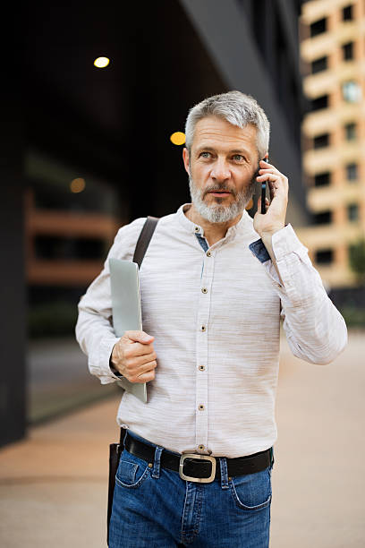 istock Businessman walking and talking on phone in urban setting 2222272889