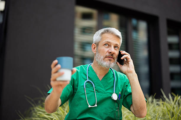 istock Doctor drinking coffee and talking on phone during break 2222273105
