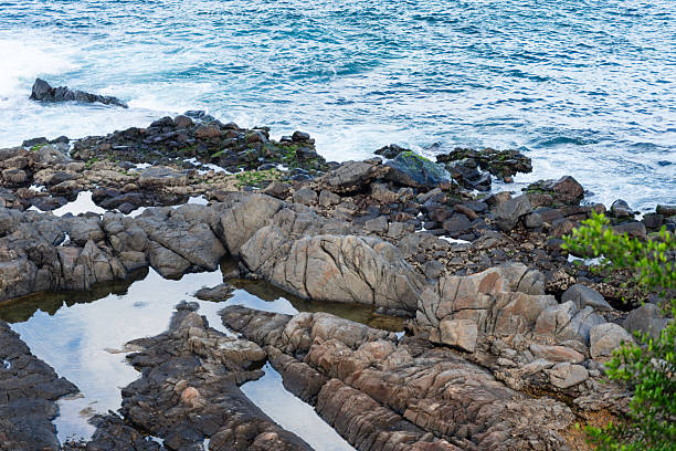 istock View of beach waves breaking on dark rocks during low tide. Paradise beach. Impeccable nature. 2222274010