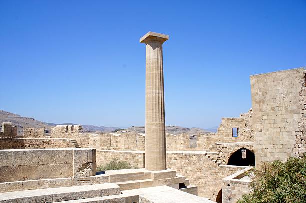 Ruins of the ancient Acropolis rise dramatically above the whitewashed village of Lindos, on Rhodes Island, Greece. Perched atop a 116-meter-high cliff, this iconic archaeological site combines centuries of history—a Doric temple to Athena Lindia (4th century BC), Hellenistic stoas, Byzantine and medieval fortifications—overlooking the Aegean Sea. The scene captures the blending of ancient Greek, Roman, and medieval architecture, echoing the spiritual and strategic importance of Lindos through the ages