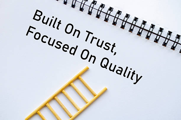 istock Built On Trust Focused On Quality on notebook with miniature ladder on table 2222276729