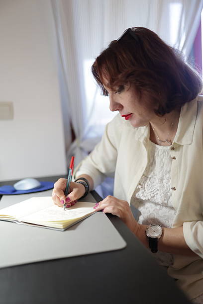 istock Businesswoman writing notes in notebook at office desk 2222277165