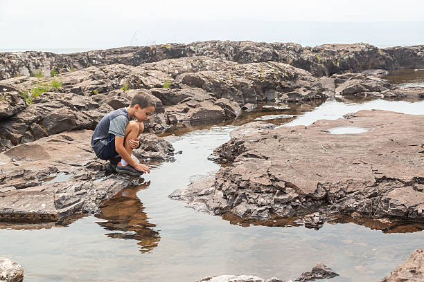 istock Boy Exploring Rocky Shoreline of Lake Superior 2222282977
