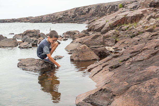 istock Boy Exploring Rocky Shoreline of Lake Superior 2222283413
