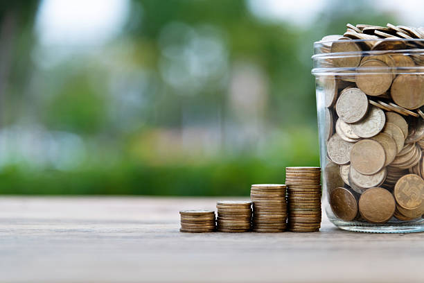 istock Coin stairs and jar on wooden table 2222285739