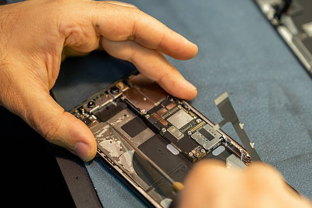 istock Expert Phone Repair Technician Replacing Parts Inside a Smartphone on a Workbench in a Well-Lit Workshop 2222286854