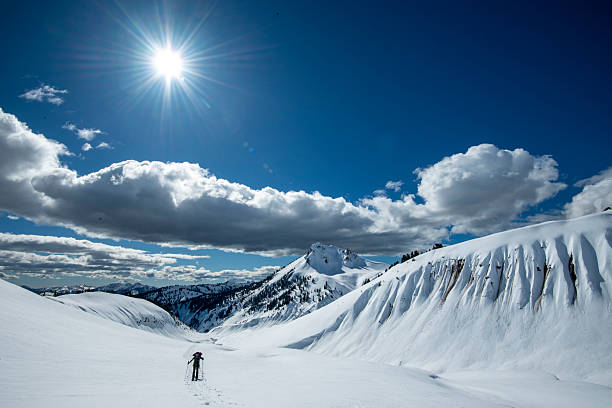 Ski tips of a single ski tourer climbing toward a snow covered mountain ridge in the backcountry in the French Alps