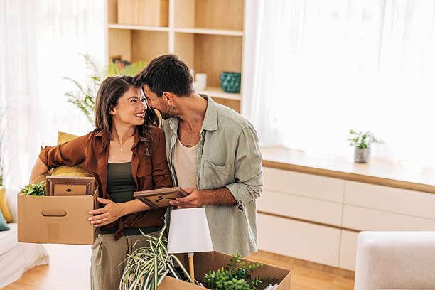 istock Young couple moving into new home carrying boxes and smiling 2222291500