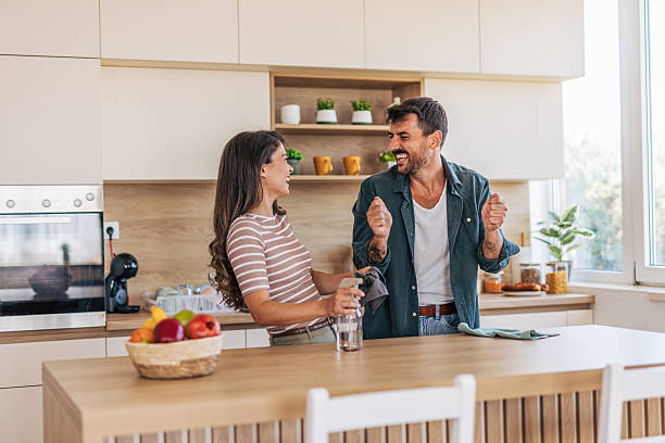 istock Happy couple having fun while cleaning kitchen island together 2222294039