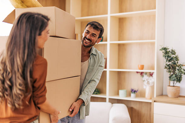 istock Happy couple carrying stacked boxes into new home 2222294099