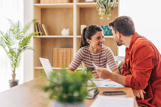 istock Young couple smiling and using credit card at home office 2222294549