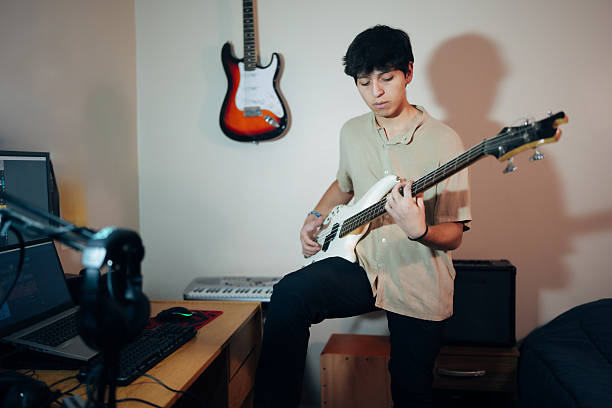 istock Young musician playing bass guitar in home studio 2222294578