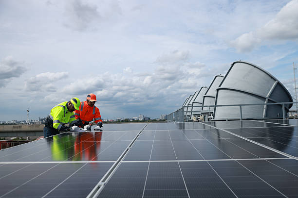 istock Professional Solor engineering team with green and orange safety jacket and safety hat check and service solar panel on solar roof project , green energy renewable energy 2222294728