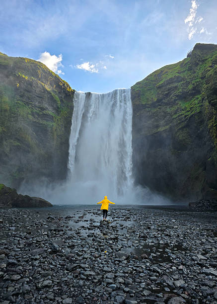 istock Skogafoss waterfall cascading in Iceland with vibrant yellow jacket under clear blue sky 2222294735