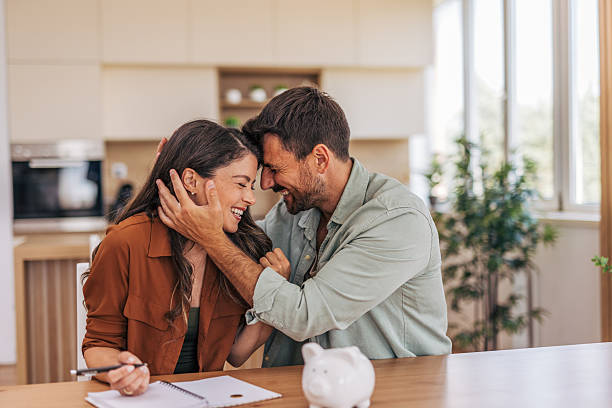 istock Happy couple embracing while doing home finances in the kitchen 2222294949