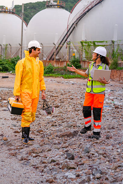 istock Two environmental researchers walk back from shoreline testing. They carry safety gear, a toolbox, a respirator mask, and a laptop after collecting water samples from a contaminated coast. 2222295508