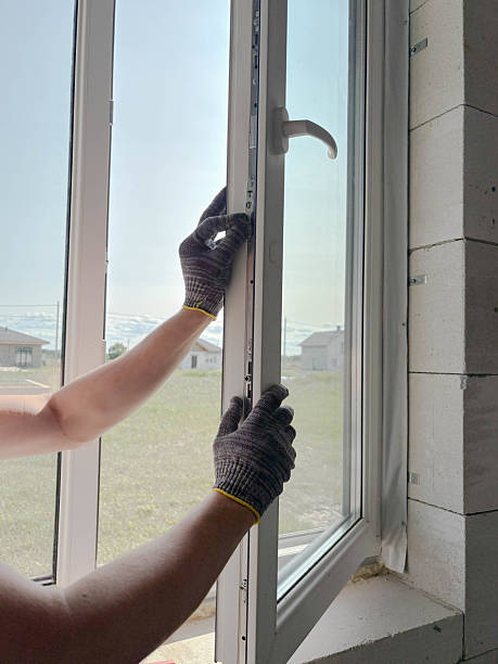 istock A man's gloved hands adjust a plastic window in a new country house. Installing plastic windows in a country house. 2222299492