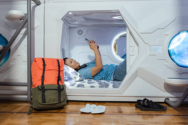 istock Young woman relaxing in a modern capsule hostel sleeping pod 2222299529
