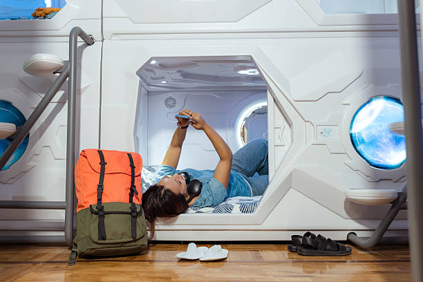 istock Young woman relaxing in a modern capsule hostel sleeping pod 2222299711
